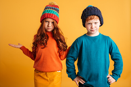 Two children wearing colorful winter clothing
